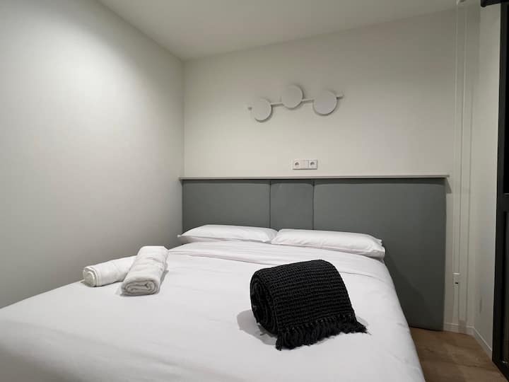 Elegante dormitorio con cama doble y armario con perchas