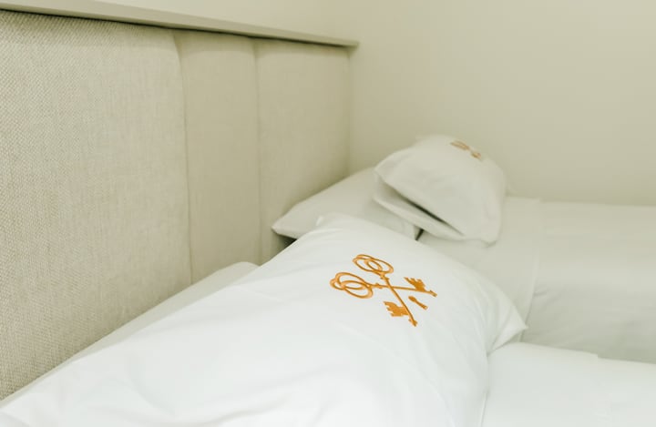 غرفة نوم أنيقة بسريرين متماثلين وخزانة مع شماعات