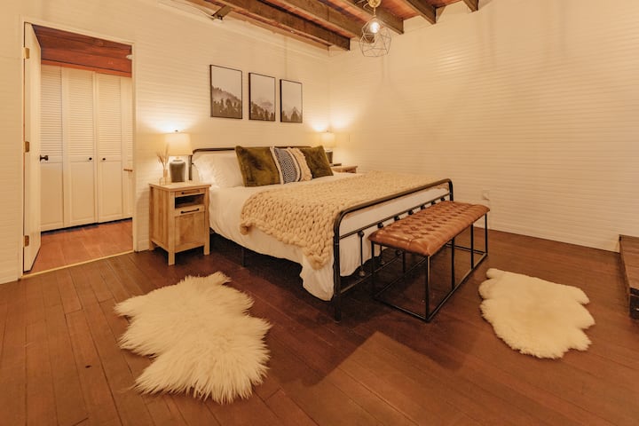 Downstairs is the spacious primary suite with exposed beams and comfy king size bed