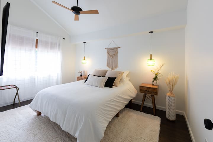 Spálňa na prízemí s vyvýšeným stropom, inteligentnou televíziou a výhľadom na dvor. 