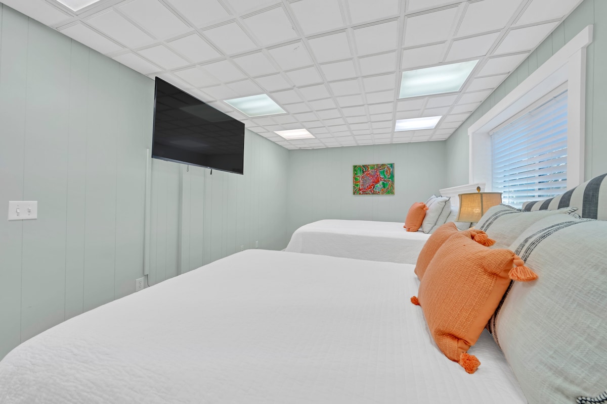 غرفة نوم في الطابق السفلي تضم سريرين كوين