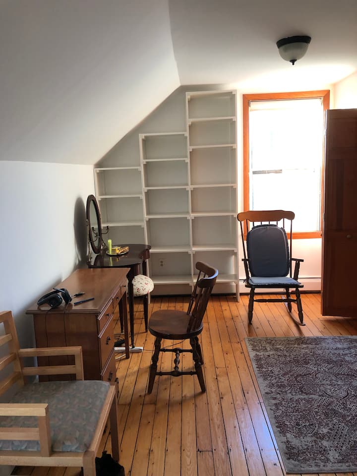 Velika glavna spavaća soba s radnim stolom, komodom, stolicama i garderobom.