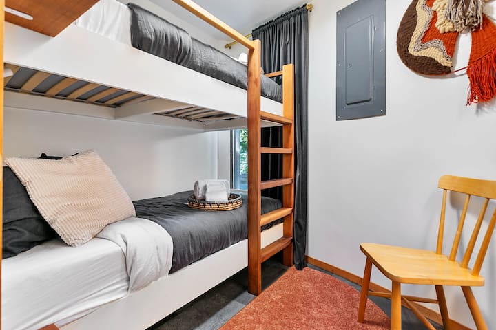 The bunk room is in the lower level, adjacent to the theater room. It has twin bunks and an open closet.