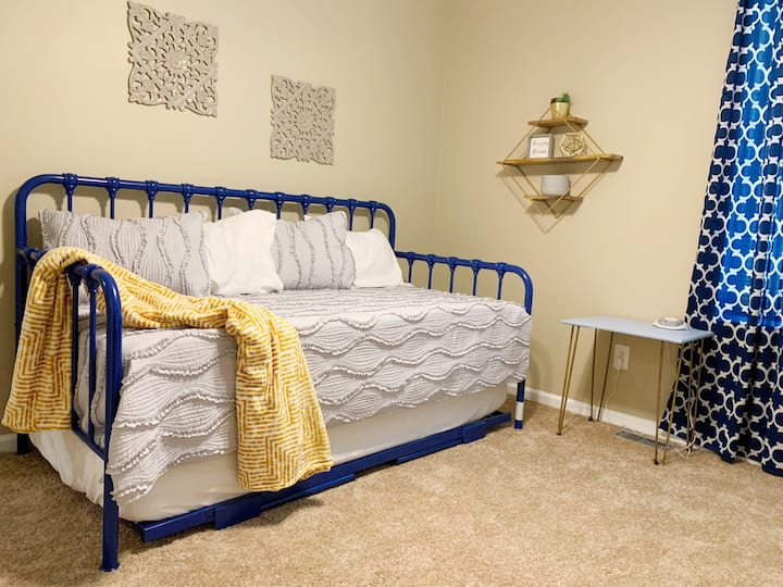 Este dormitorio tiene una cama de una plaza con una cama plegable. 