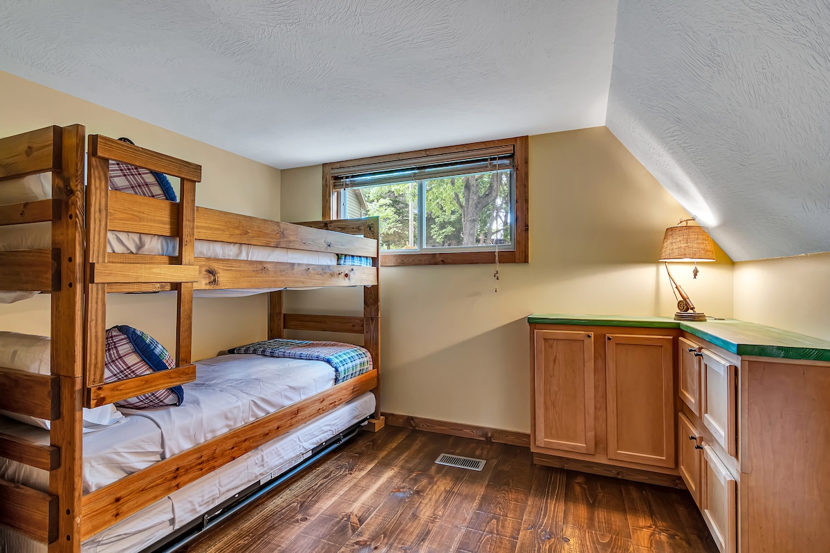 Спалня с двуетажни легла и разтегателно легло.  Изобилие от място за съхранение с шкафовете и подовете от твърда дървесина.