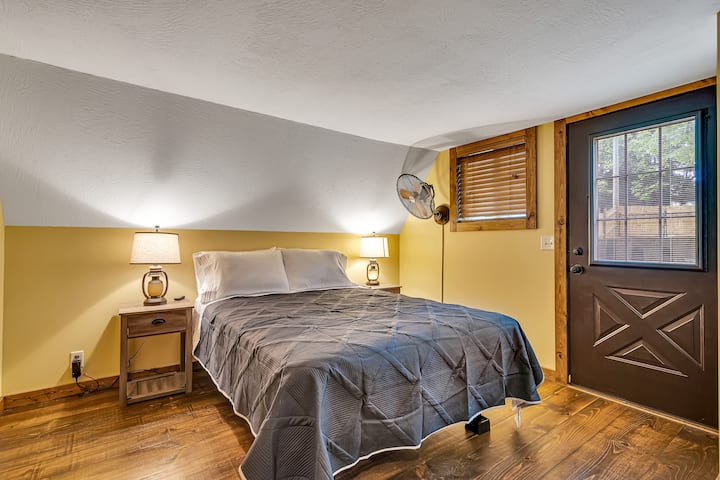 Bedroom with Queen size bed, hardwood floors, wood accents, and private bath.