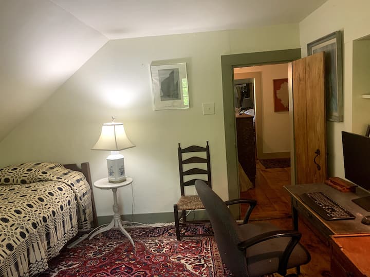 ห้องนอนที่เล็กที่สุดพร้อมเตียงเดี่ยวของคนงานและโต๊ะคอมพิวเตอร์ คุณสามารถมองเห็นห้องโถงชั้นบน