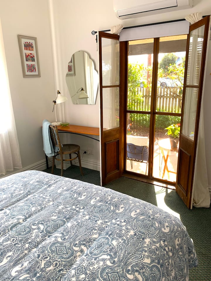 The main bedroom opens to the sunny verandah through French Doors
