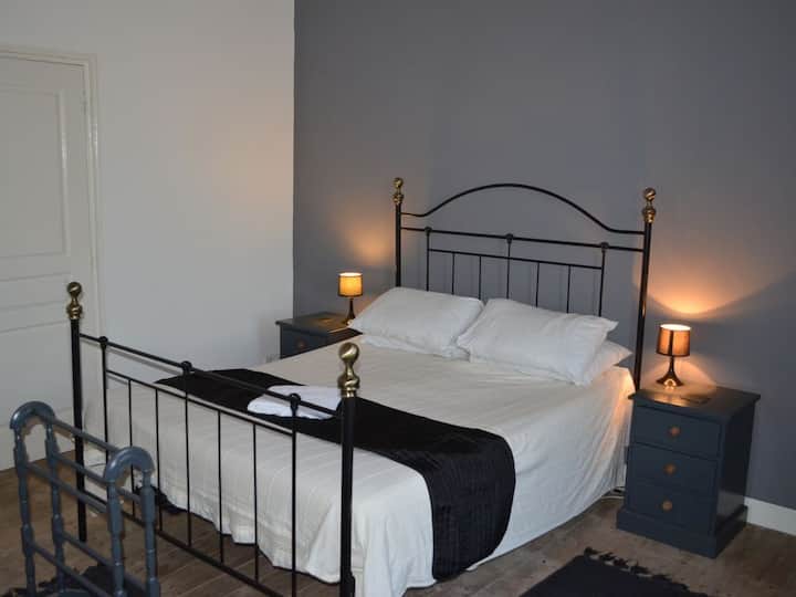 Chumba cha kulala cha wazazi ghorofani, mlango ulio upande wa kushoto unatoa ufikiaji wa bafu la kujitegemea na kwenye kona ofisi ambayo hayaonekani kwenye picha.