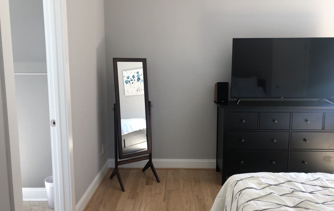 King sized bed with dressers and walk in closet with full bathroom.  