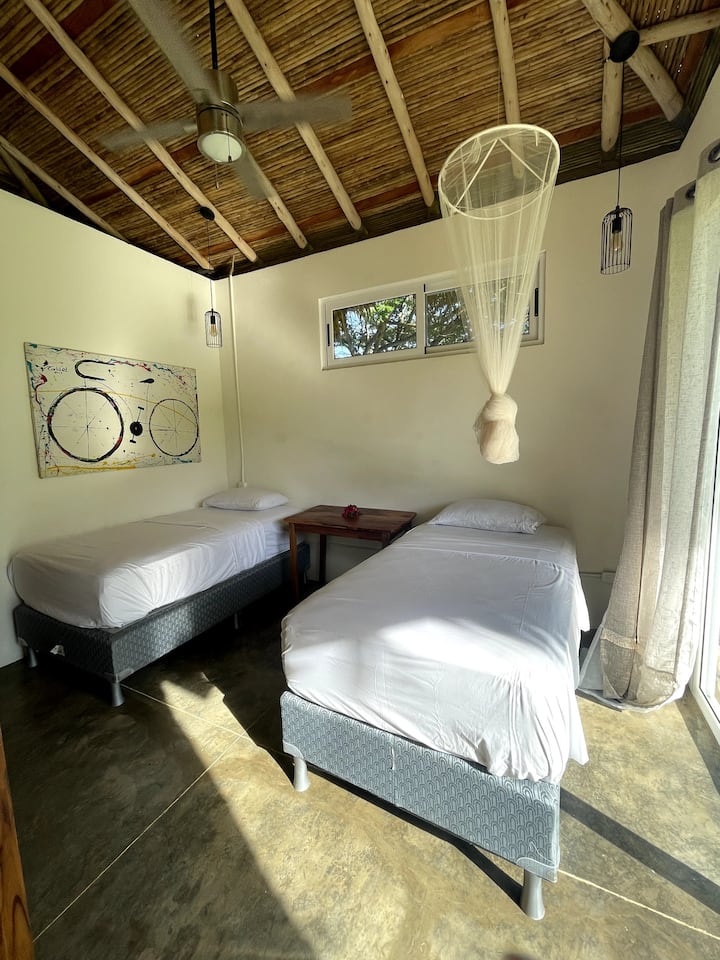 The second bedroom with ensuite bathroom can be made up with 2 single beds or 1 Queen.  It has a built in closet with hanging space and drawers; sliding doors to the front patio and screens on the windows and a ceiling fan.