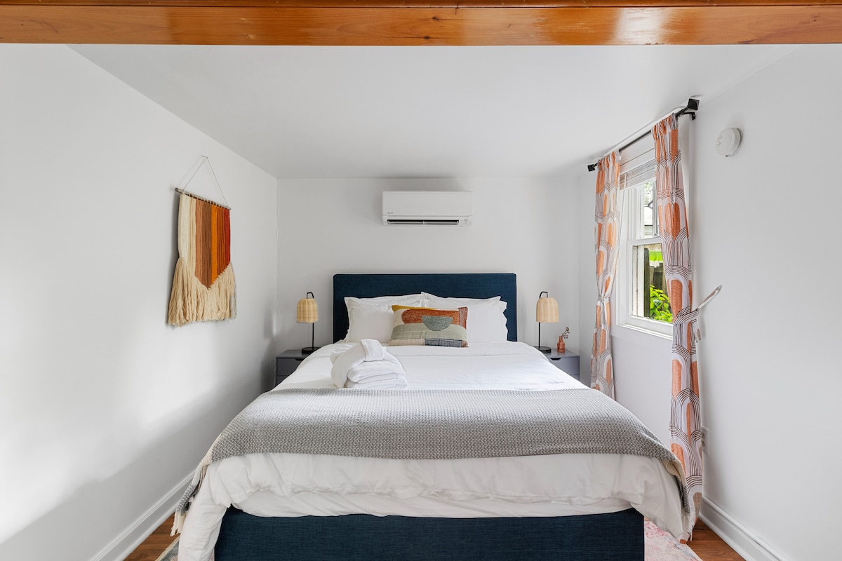 Bedroom in the downstairs apartment with a queen size bed and ensuite bathroom and closet