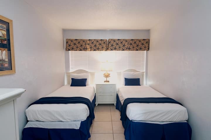 أهلًا بك في غرفة نوم الضيوف المريحة التي تحتوي على سريرين مزدوجين، مما يوفر مسكنًا مريحًا وجذابًا لقضاء ليلة مريحة.