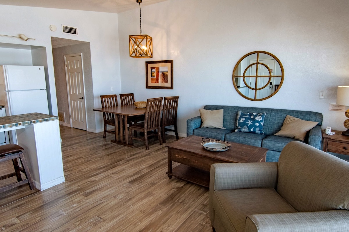 Опуштете се во пространата дневна соба со доволно места за седење. Каучот лесно се трансформира во кауч на спуштање за дополнителен простор за спиење. Трпезариската маса е совршена за семејни оброци или ноќни игри, создавајќи драги моменти во вашиот рај покрај плажа. 