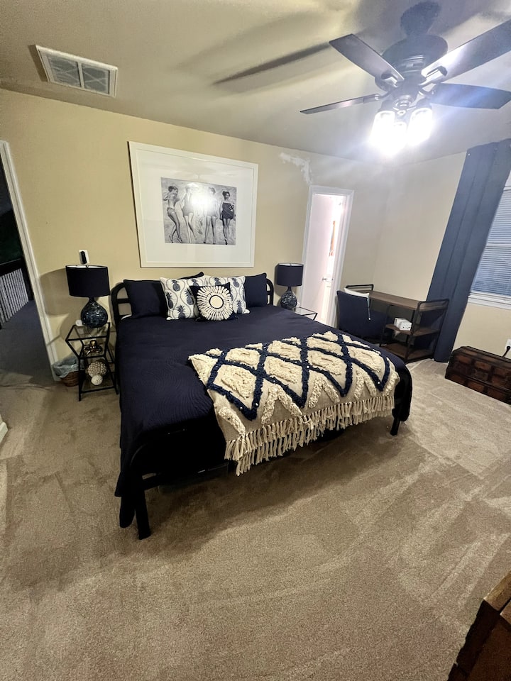 Dive into Coastal Bliss!  Bedroom 3 is a dreamy escape with a king bed wrapped in a cozy blue comforter. Escape from a day at the beach with a smart TV, large dresser, and a snapshot of '50s beach glamour. Sleeps 3, smiles guaranteed! 