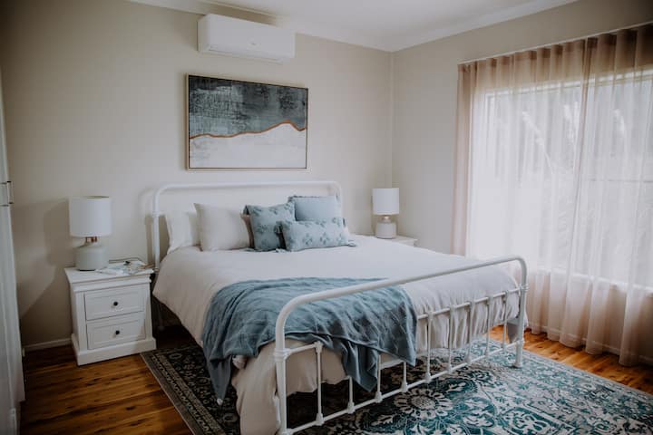 Bed 1 - make a beeline for this King bedroom with cool and relaxing blues. This room is super spacious with plenty of storage to stash your suitcases and has reverse cycle air conditioning to ensure your comfort whatever the weather.