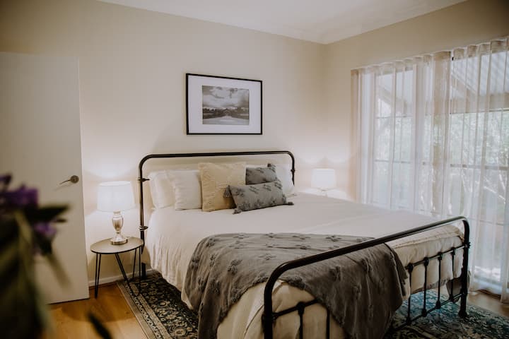 Chumba cha 1 cha kulala kina kitanda kizuri cha King kilicho na miti yenye kutu nje kidogo ya dirisha lako.