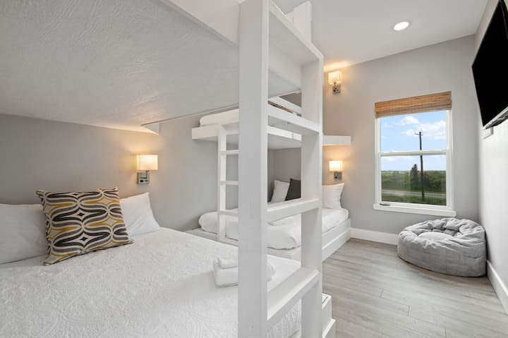Chambre superposée avec lits queens en bas et jumeaux en haut.