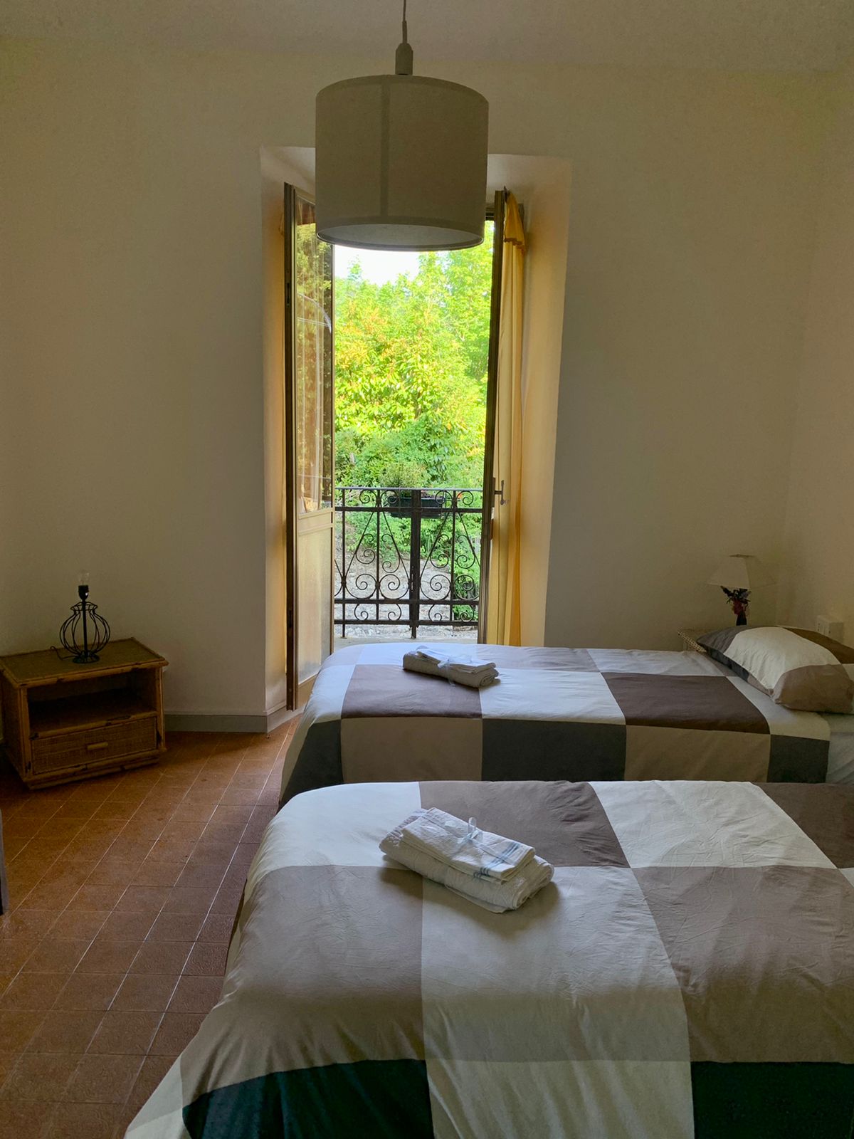 غرفة نوم مع تراس وسريران مفردان يمكن دمجهما معًا