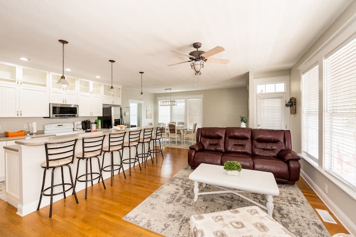 طاولة جلوس تطل على المطبخ وغرفة معيشة مريحة. (لقد أعدنا ترتيب الأثاث قليلاً، ولكن لا يزال لدينا أريكة وكرسيين في غرفة المعيشة لمجموعتك للتجمع بشكل مريح).