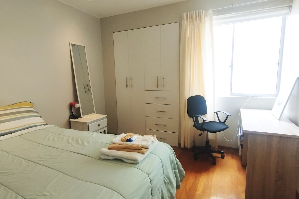 Habitación con cama doble, escritorio, armarios grandes, ventana con vista interior, cortinas opacas y cortinas normales.