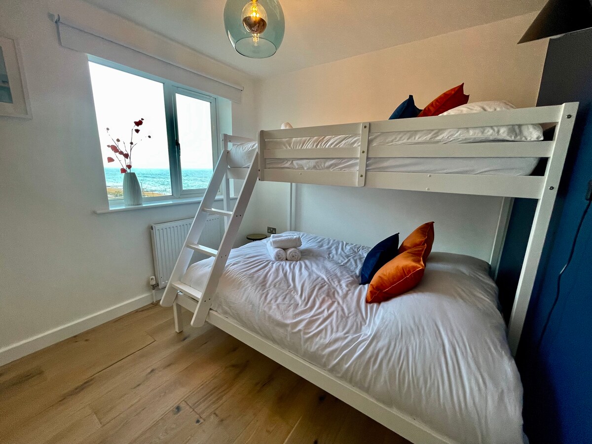 Ljust andra sovrum med utsikt över havet och stranden.