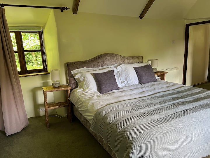 ห้องนอนใหญ่พร้อมเตียงขนาดคิงไซส์ (สะดวกสบายมาก) คานไม้โอ๊คและวิวสวนและต้นไม้ทั้งด้านหน้าและด้านหลัง