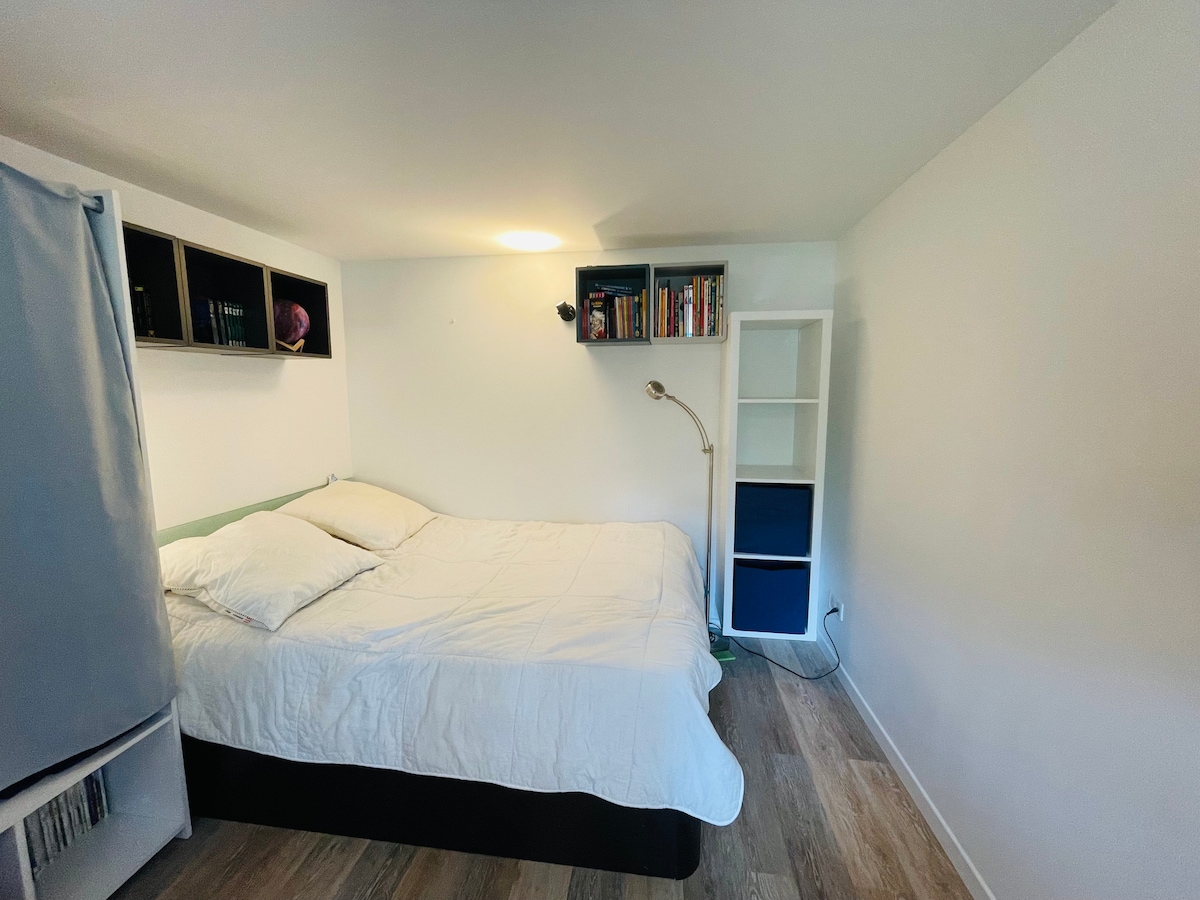 Chumba kidogo cha kulala cha watu wawili na dawati linalotazama bustani upande wa kusini