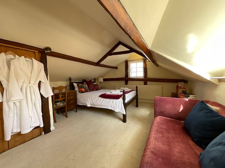 „Червената“ спалня с двойно легло и диван, на които да се отпуснете и да прочетете книга.