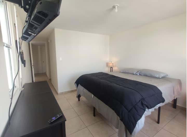 Chumba cha kulala cha Mwalimu kina kitanda cha ukubwa wa mfalme, taa mbili na nguo mbili za kuweka nguo zako.  Pia kuna Smart TV inayopatikana kwa matumizi yako.