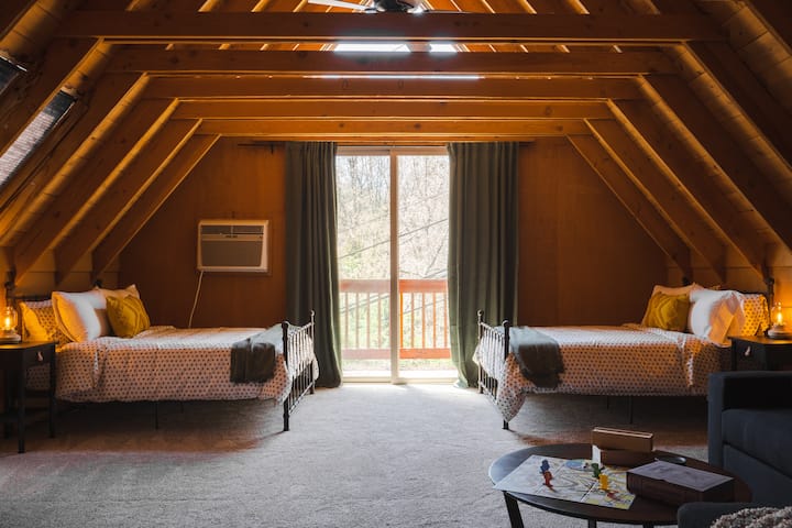 The loft is home to two full size beds alongside a sectional sofa with a Queen sleeper mattress, 65" Samsung Smart TV, board games, skylights and cozy carpeting. 