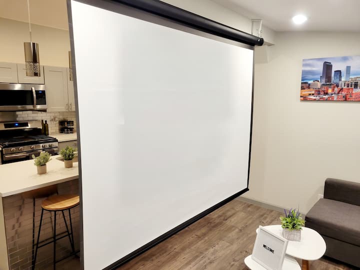 Aljašský dom má inteligentný projektor so zasúvateľnou obrazovkou na diaľkovom ovládaní. Môžete použiť streamovacie služby, ktoré projektor ponúka, alebo môžete premietať telefón priamo na obrazovku. 