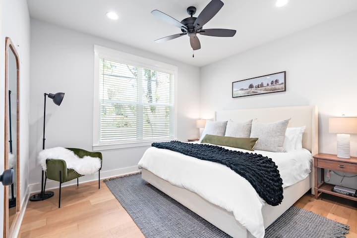 The first guest bedroom has a cozy king bed with seating. Private bathroom and walk-in closet attached,