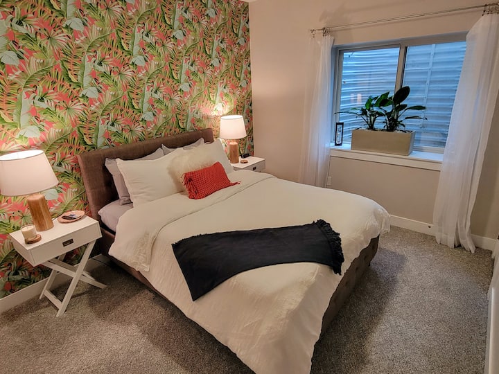 Basement bedroom with Queen Bed, TV, in-room coffee station, and private bathroom.