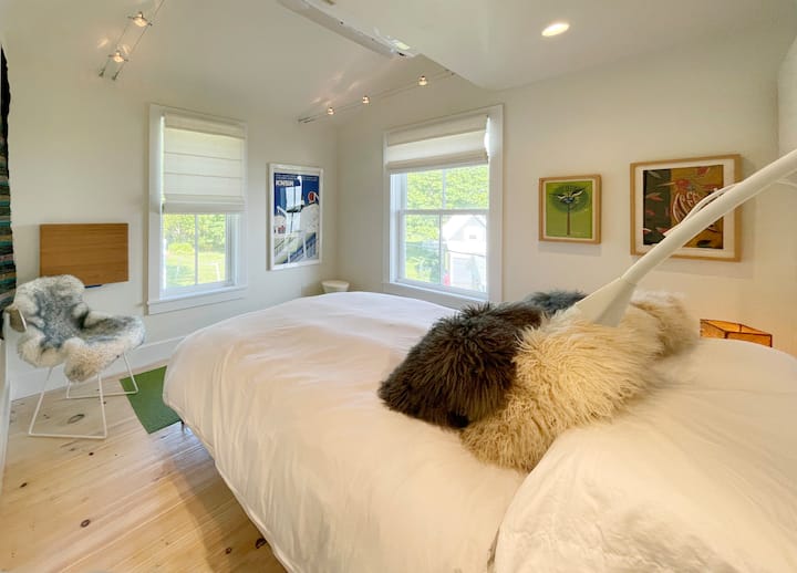 快適なマットレス、プレミアムリネン、ユニークなアート作品を備えた寝室。