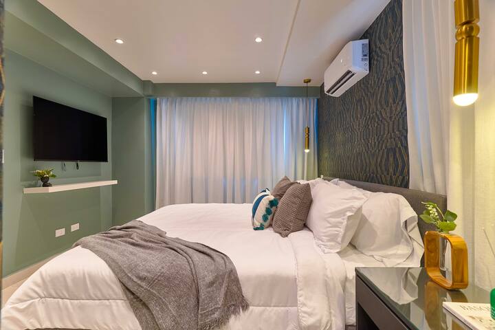El lujoso y espacioso dormitorio cuenta con una cama tamaño king, baño privado con ducha de efecto lluvia, amplio vestidor, aire acondicionado, TV inteligente de 50 PULGADAS, WIFI rápido y escritorio.