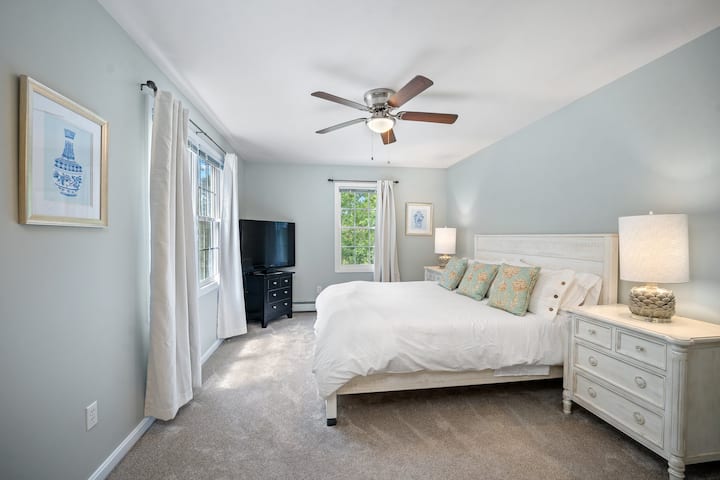 ห้องนอนหลักพร้อมเตียงคิงไซส์ห้องน้ำในตัวและตู้เสื้อผ้าแบบวอล์คอิน 