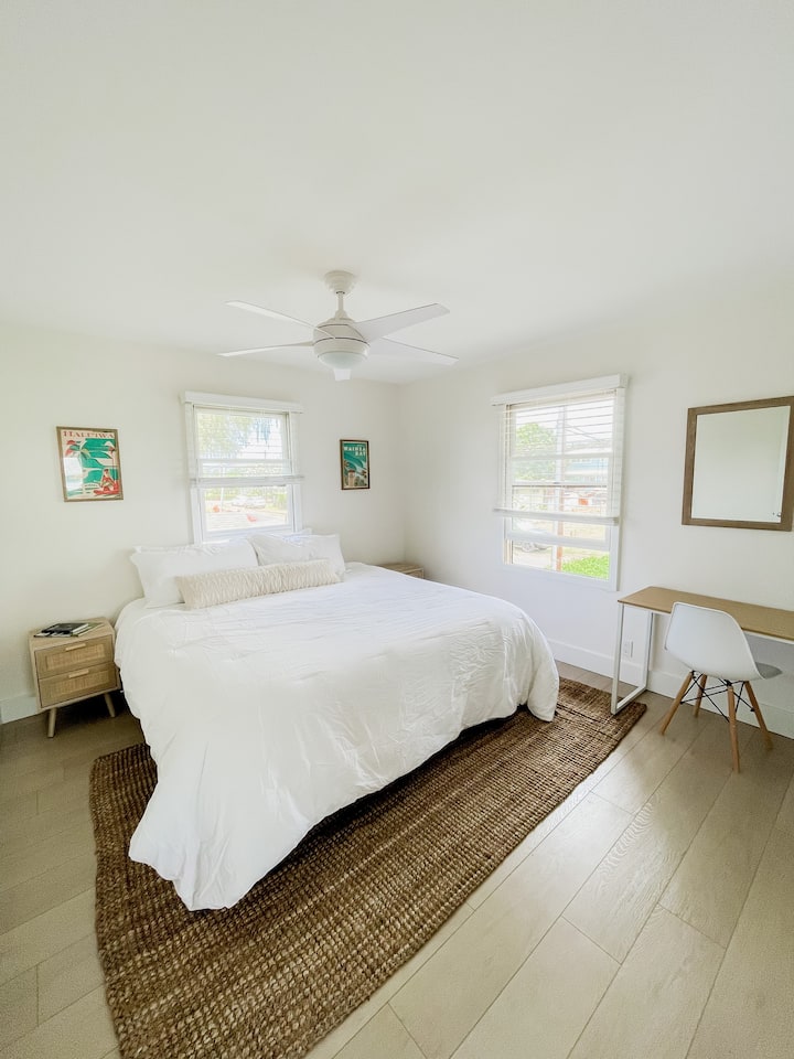 غرفة نوم بسرير كبير وخزانة ملابس ومكتب وطاولات جانبية للسرير وفنون محلية وإطلالات على الجبال