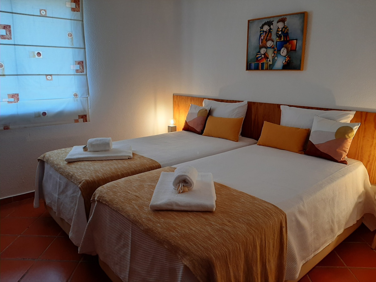 Bedroom at Pé no Mar & Golf with air conditioning, two beds, wardrobe and dressing table.