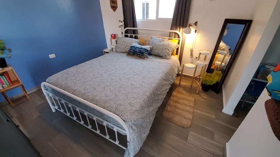 Queen size bed with nightstands, full length mirror next to closet and bathroom. 