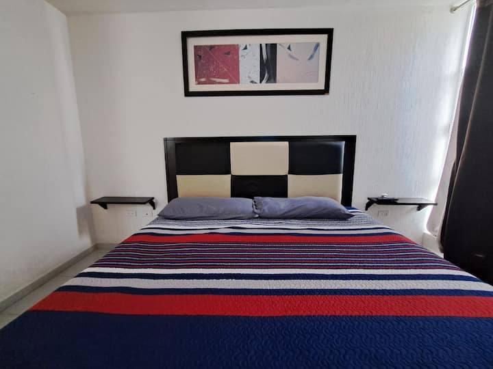 Მთავარი საძინებელი დიდი ზომის საწოლით, ტელევიზორით, შესასვლელი კარადით და აბაზანა-ტუალეტით საძინებელში