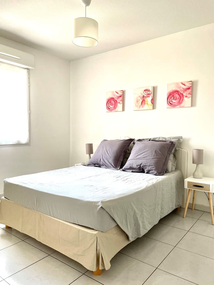 Საძინებელი დიდი კარადითა და ფანჯრით, რომელიც საცხოვრებლის გამწვანებულ სივრცეებს გადაჰყურებს