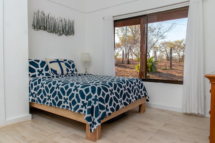 Dormitorio de invitados con cama tamaño queen y dos camas individuales