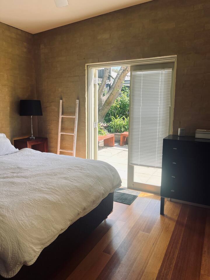 سرير كوين ومساحة خزانة ملابس مع علّاقات تفتح على الفناء - يشترك فيها ضيوفك