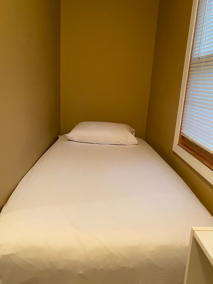 La cama individual encaja perfectamente en el pequeño dormitorio.