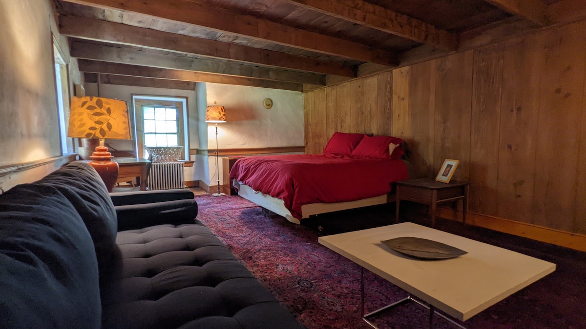 Bedroom #3 is quite spacious with a queen-size bed, writing desk, dresser, nightstand, couch, chair, and table. 