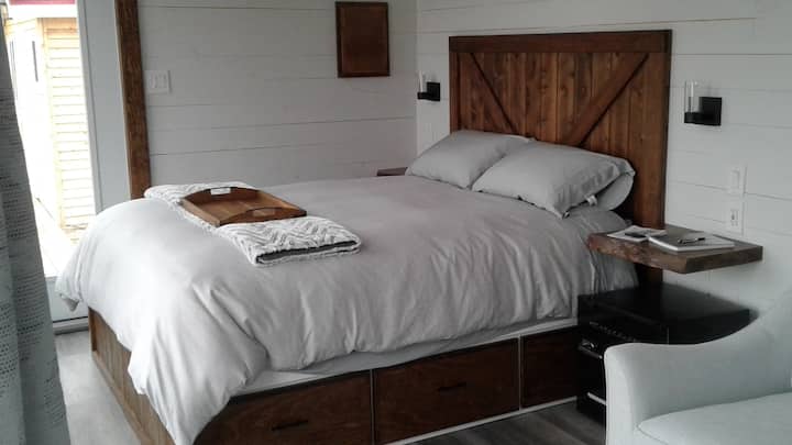 Guesthouse, custom built queen bed with drawers and live edge night tables.