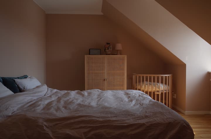 Chumba cha kulala kilicho na kitanda cha sentimita 180 na kitanda cha mtoto, madirisha upande wa mashariki yenye mwonekano wa vilima vya paa na kuta za pete. Hakuna ufahamu. 