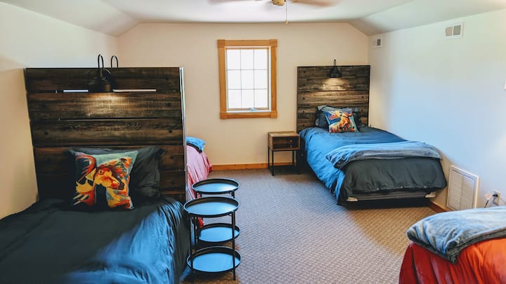 غرفة النوم العلوية في الطابق الثالث - 4 أسرّة XL مزدوجة لكل منها مصباح قراءة وطاولة جانبية ومنفذ شحن. تطل على حمام السباحة ومنطقة الاستجمام.