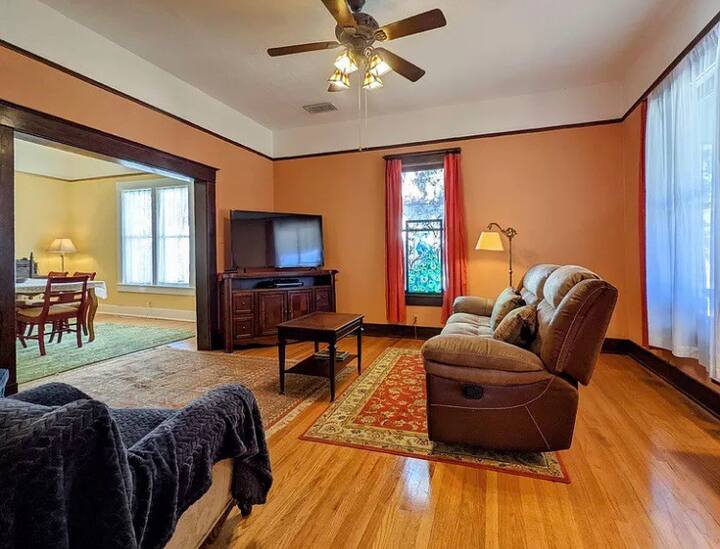 Living room with comfortable seating and large TV with Dish Network.